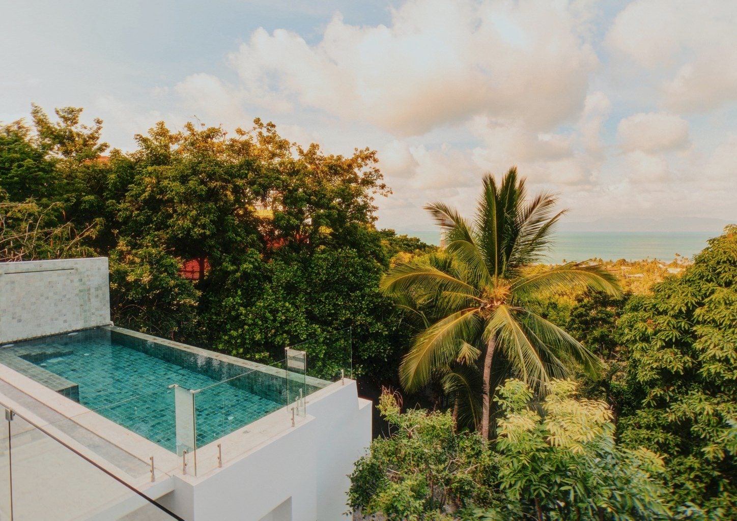 Infinity pool of Villa Caetaro above the treetops, looking out to the sea